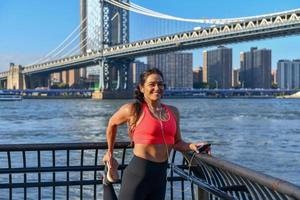 vrouw jogger uitrekken door de Manhattan brug in de Dombo Oppervlakte van Brooklyn in nieuw york stad foto