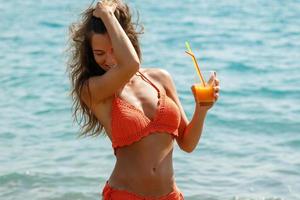 vrouw Aan de strand met een glas van cocktail foto