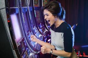 vrouw is gelukkig van haar winnen in sleuf machines foto