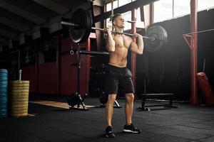 gespierd Mens gedurende zijn gewichtheffen training in de Sportschool foto