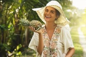 mooi vrouw vervelend brede rand hoed in de tropisch tuin foto