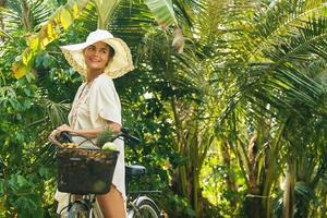 mooi vrouw vervelend brede rand hoed in de tropisch tuin foto