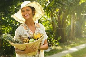 mooi vrouw vervelend brede rand hoed in de tropisch tuin foto