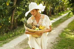 mooi vrouw vervelend brede rand hoed in de tropisch tuin foto