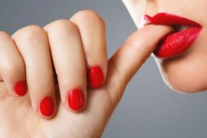 schoonheid en cosmetica. vrouw mond en nagels met rood manicure en lippenstift. foto