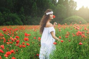 mooi vrouw in veld- met een veel van papaver bloemen foto