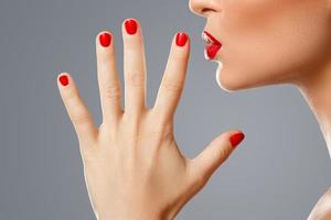 schoonheid en cosmetica. vrouw mond en nagels met rood manicure en lippenstift. foto