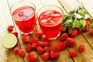 verfrissend drinken met framboos en aardbei Aan houten tafel foto