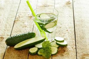 ontgiften water met komkommer Aan houten tafel foto