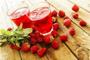 verfrissend drinken met framboos en aardbei Aan houten tafel foto