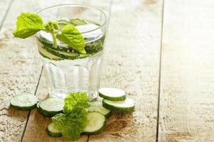 ontgiften water met komkommer Aan houten tafel foto