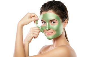 vrouw met groen afpellen masker Aan haar gezicht foto