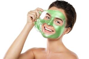 vrouw met groen afpellen masker Aan haar gezicht foto