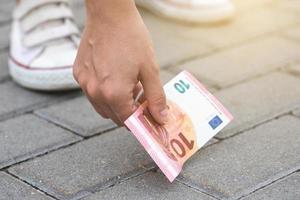 vrouw is plukken tien euro bankbiljet van de grond foto