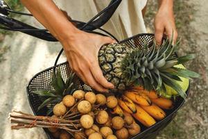 mand Aan de fiets vol van verschillend exotisch fruit foto