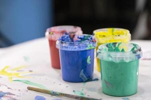 waterverf verven in potten van verschillend kleuren Aan de achtergrond van kinderen tekeningen. kinderen creativiteit. foto