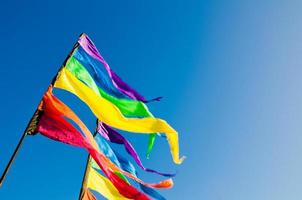 kleurrijk regenboog driehoek vlag shows omhoog tegen de blauw lucht. foto