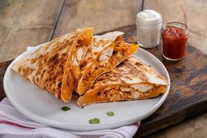 getrokken kip en Cheddar quesadilla's Aan een bord foto