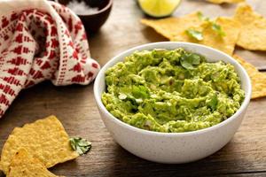 dik eigengemaakt guacamole in een kom met tortilla chips foto