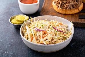 traditioneel cole slaw salade, kant schotel voor getrokken varkensvlees belegd broodje foto