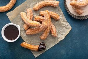 eigengemaakt churros met kaneel suiker Aan perkament foto