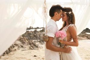 gelukkig getrouwd paar is vieren hun bruiloft Aan de strand Bij tropisch eiland foto