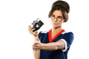 vrouw model- in wijnoogst kijken Holding retro camera in haar handen foto
