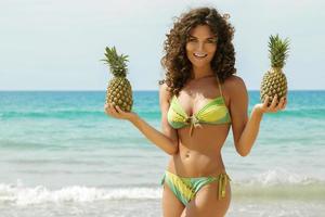 vrouw met een ananas Aan de strand foto