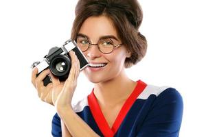 vrouw model- in wijnoogst kijken Holding retro camera in haar handen foto