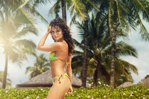 mooi vrouw met gekruld haar- en palm bomen Aan de strand foto