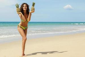 vrouw met een ananas Aan de strand foto