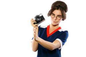 vrouw model- in wijnoogst kijken Holding retro camera in haar handen foto