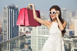 mooi vrouw met een boodschappen doen Tassen in de groot en modern stad foto