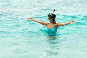 vrouw in de zee gedurende snorkelen in blauw water foto