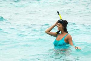 vrouw in de zee gedurende snorkelen in blauw water foto