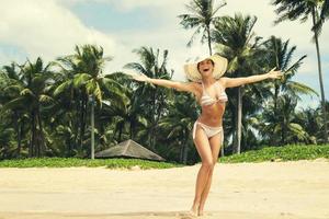 gelukkig vrouw Aan de strand met een palm bomen Aan achtergrond foto