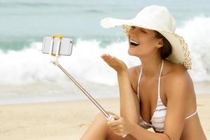 vrouw vervelend hoed en ontspannende Aan de strand foto