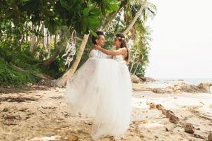 mooi paar is vieren hun bruiloft Aan de tropisch strand foto