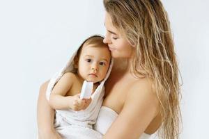 jong en gelukkig moeder en haar schattig weinig baby na het baden foto