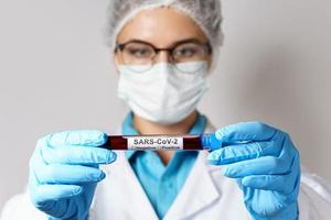 vrouw dokter is Holding een bloed monster van de SARS-CoV-2 foto