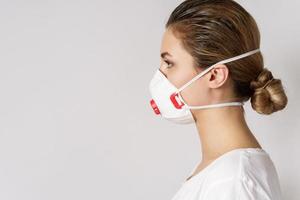 jong vrouw is vervelend een gezicht masker voor bescherming tegen virus foto