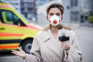 TV nieuws verslaggever is maken reportage over een virus epidemie in de stad foto