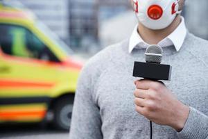 nieuws verslaggever vervelend een het voorkomen masker en sprekend in een microfoon foto