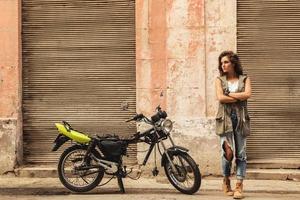vrouw model- is poseren naast oud motorfietsen foto