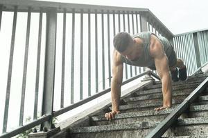 gespierd Mens is aan het doen Opdrukken gedurende gymnastiek training Aan een straat foto