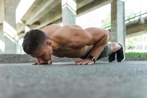 gespierd Mens is aan het doen Opdrukken gedurende gymnastiek training Aan een straat foto