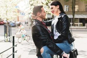 mooi paar in liefde vervelend leer jassen gedurende een datum Aan een stad straat foto