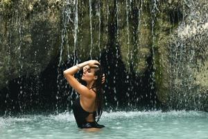 nat en sexy vrouw in mooi waterval met blauw water foto