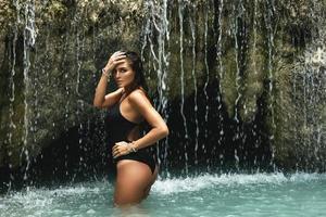 nat en sexy vrouw in mooi waterval met blauw water foto