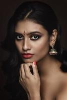 portret van Indisch vrouw met mooi bedenken en kapsel Aan bruin achtergrond foto